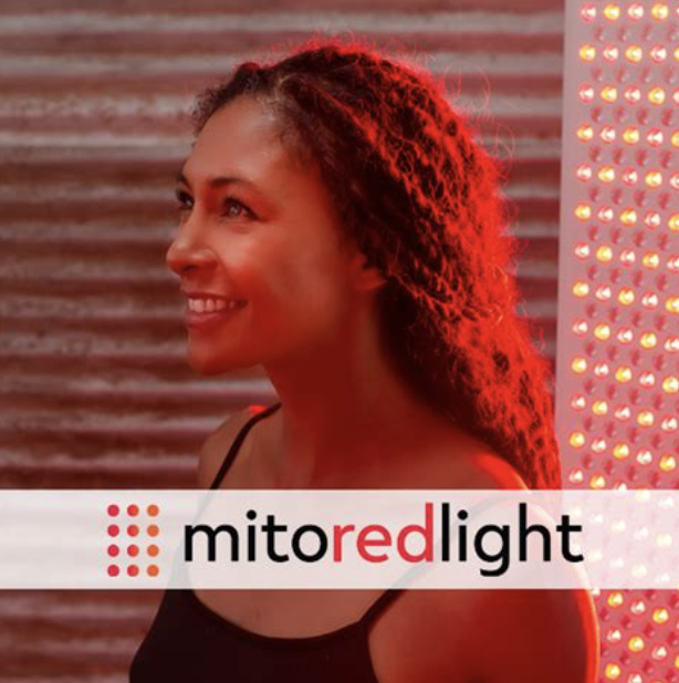 Mito Red Light. Image of a woman looking sideways, wearing a black tank top with curly hair smiling
